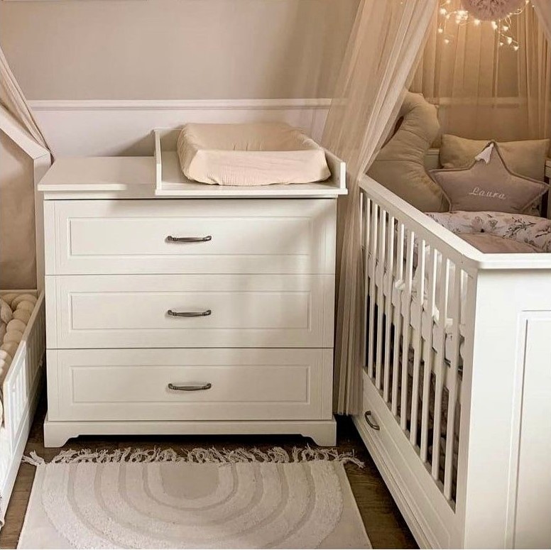 Bílá dětská komoda s přebalovacím pultem a úložnými zásuvkami v elegantním designu.